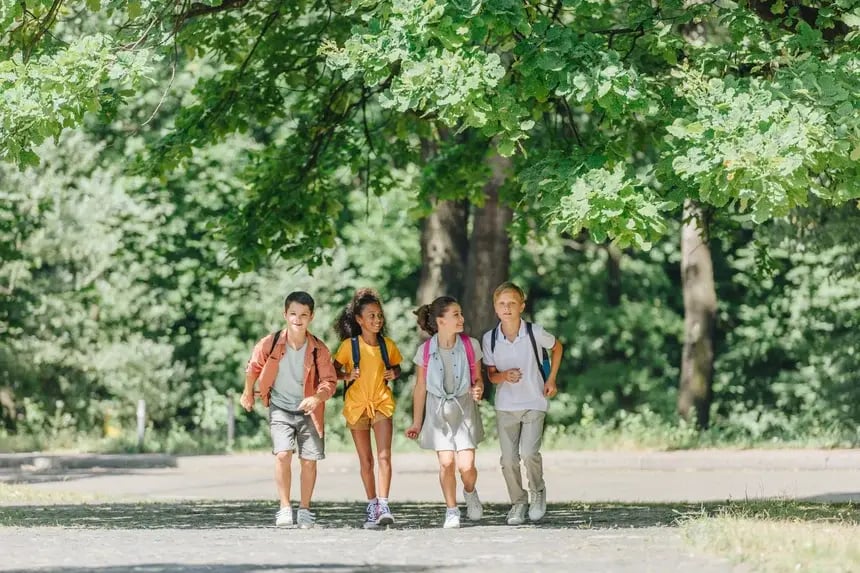 four-happy-multicultural-schoolkids-with-backpacks-2023-11-27-05-22-59-utc