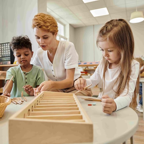 teacher-talking-to-multiethnic-kids-while-playing-Villa-montessori